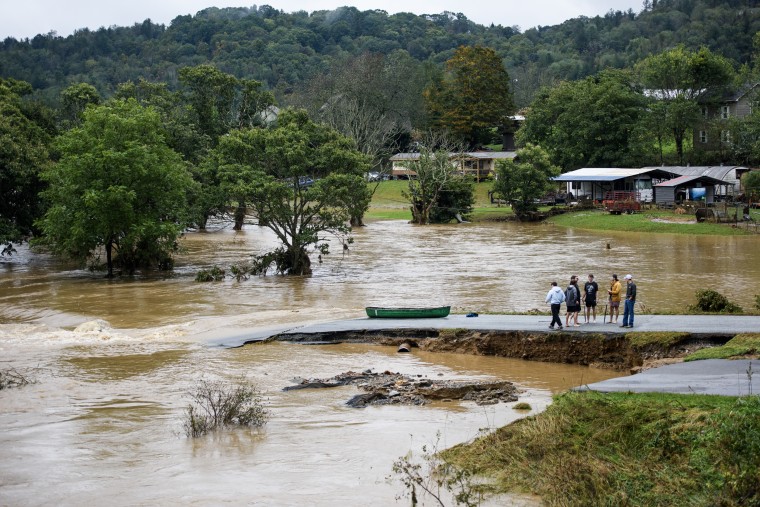 Friends talk after canoeing the flooded South Fork New River on Sept. 27, 2024 in Boone, North Carolina. 