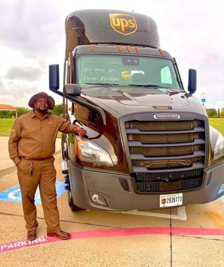 Photo of man in UPS uniform leaning against the front of UPS truck