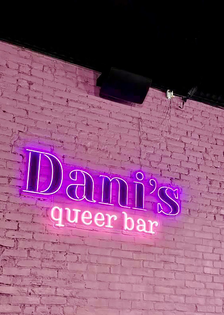 A neon sign adorns an exposed brick wall at Dani’s Queer Bar in Boston. 