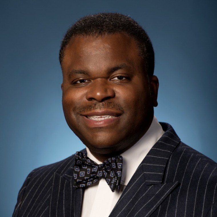 Black man in bowtie against blue gradient background 