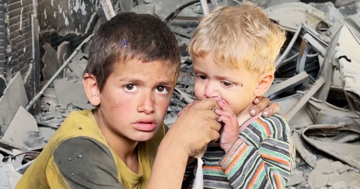 As crowds surge for bread in Gaza, a boy helps his younger brother to drink