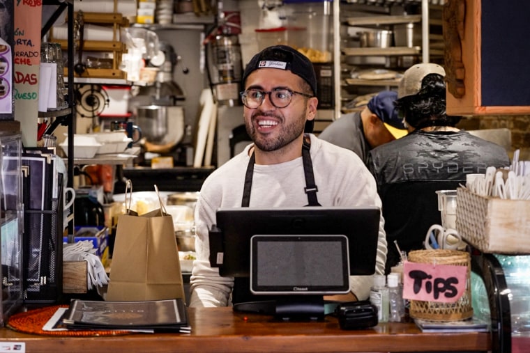 Jonathan Perez helping with orders by the register during the lunch rush at Ollín.