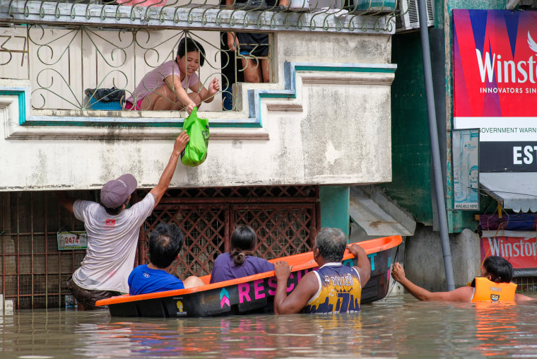 People on a boat conduct relief operations.