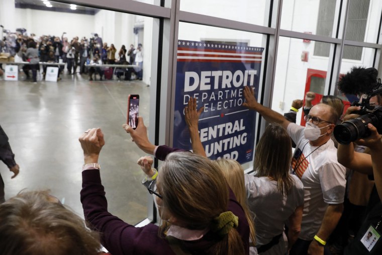 Supporters bang glass and chant while election workers count ballots.