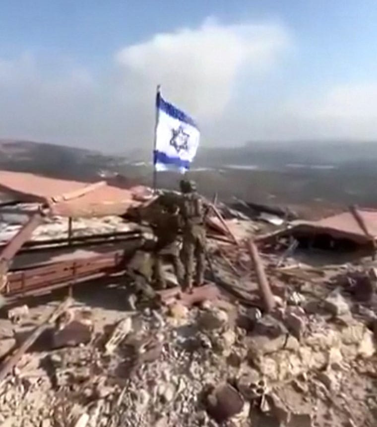 A grab from video posted on social media shows Israeli soldiers raising an Israeli flag in Lebanon's southern border village of Maroun al-Ras.