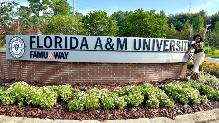 Charisse Lane poses for a photo in front of Florida A&M University sign