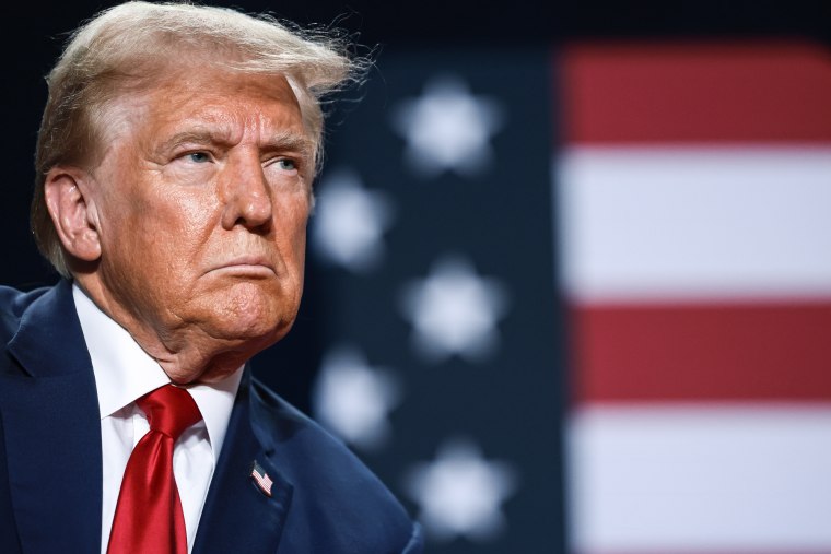 Donald Trump in front of an American flag backdrop