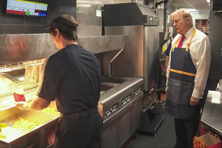 Donald Trump inside of a McDonald's kitchen wearing an apron