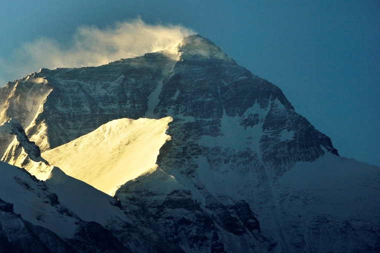 Wind blows snow off the summit at sunrise of the world's highest mountain Mount Everest, also known as Qomolangma, in the Tibet Autonomous Region