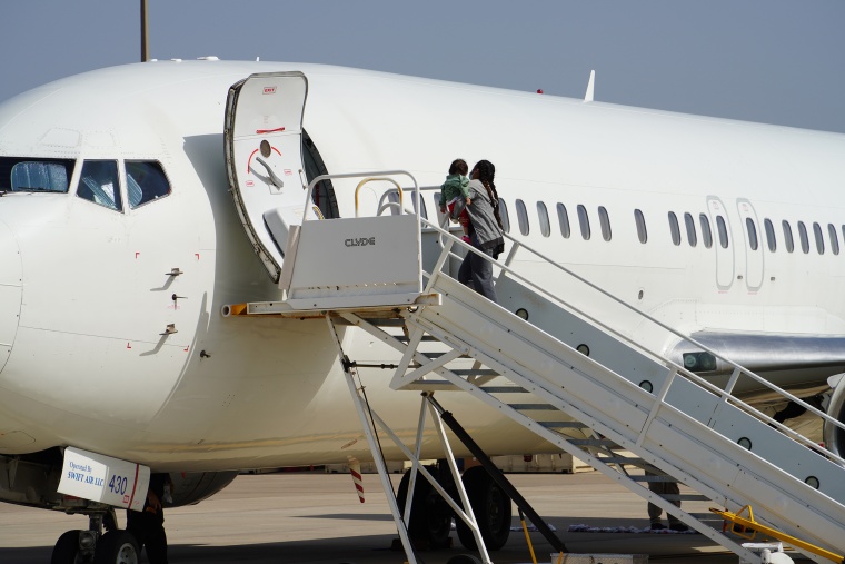 A woman with a young child boards an ICE Air flight back to Honduras Wednesday  in Harlingen, Texas.